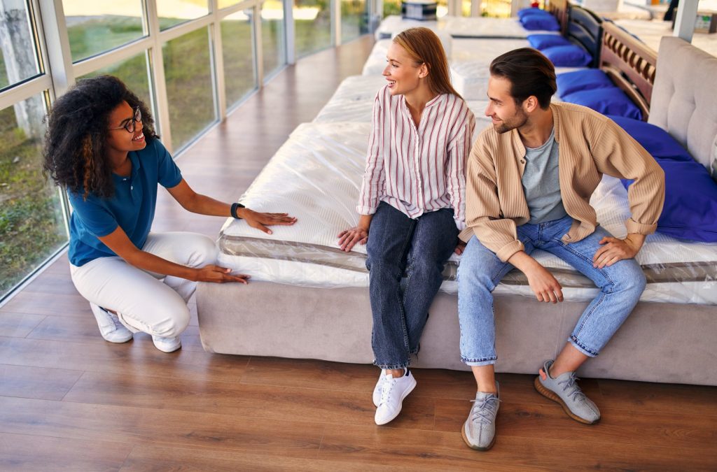people discussing mattress sale in store.